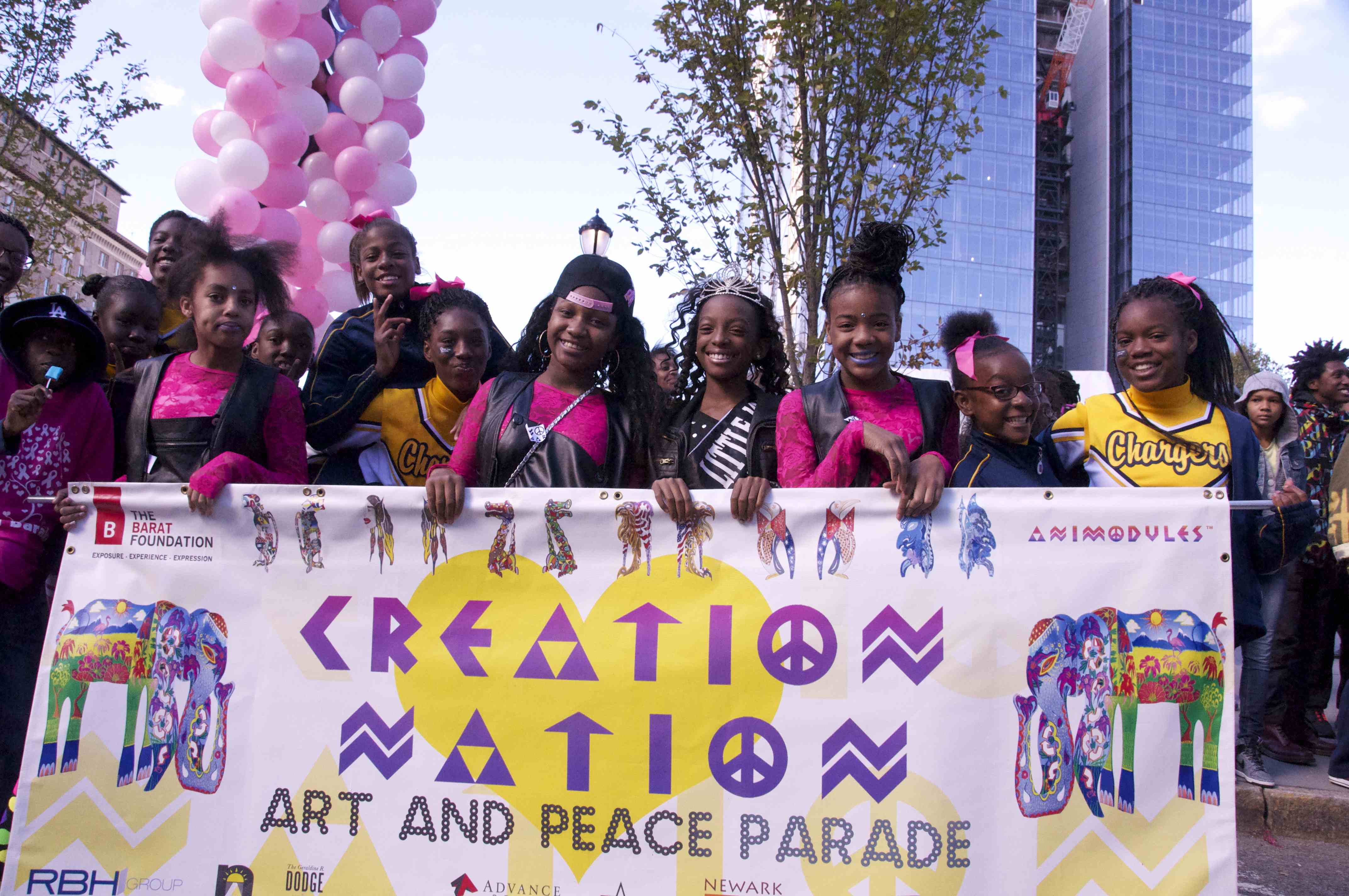 Creation Nation Art and Peace Parade banner being held in a parade